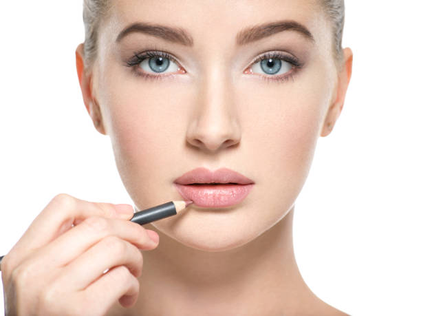 istock Woman apply lipstick with cosmetic pencil on the lips 1037624896