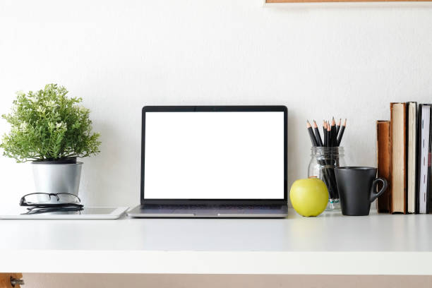 istock Mock up laptop computer on workspace with coffee, plat in pot, book,glasses and notebook paper copy space office table. 1037633386