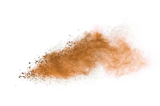 Photo of Abstract brown colored soil splash on white background. Color dust explode on background by throwing freeze stop motion.