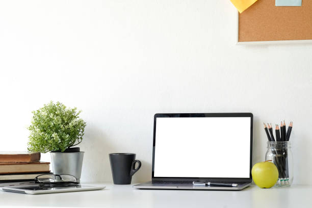 istock Mock up laptop computer on workspace with coffee, plat in pot, book,glasses and notebook paper copy space office table. 1037639164