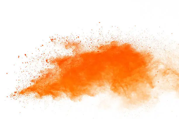 Photo of Orange powder explosion. The particles of charcoal splatter on white background. Closeup of orange dust particles splash isolated on background.