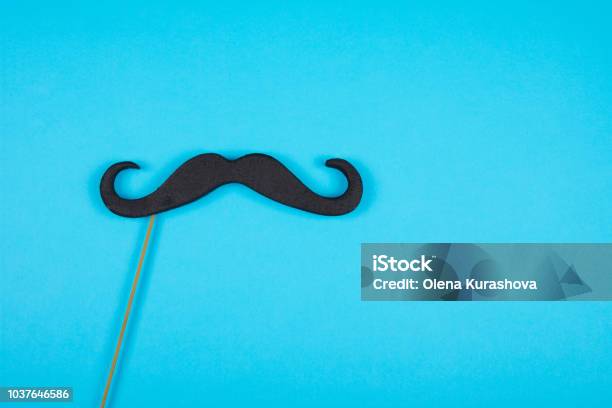 Moustache On A Stick Against A Blue Background Stock Photo - Download Image Now - Above, Artificial, Black Color