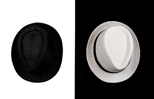 Black and white hats on the split black and white background (minimal concept)