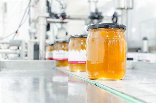 Image of jar full with organic honey, production in factory.