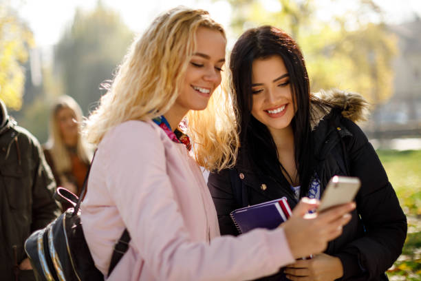 istock College students using mobile phone outdoors 1037656212