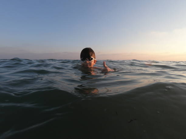 istock Happy boy swimming on the sea 1037656448