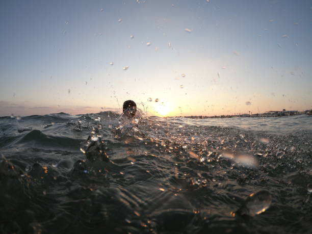 istock Happy boy swimming on the sea making splash 1037656492