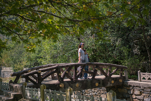 Mother and son walking at the bridge