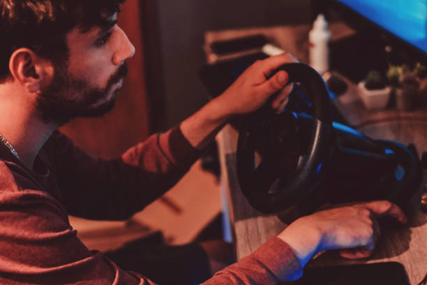 istock Man playing car racing video game at home 1037679268