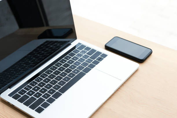 istock laptop and smartphone with blank screens on wooden table 1037679862