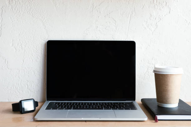 istock laptop with blank screen, smartwatch, notebook and coffee to go on table 1037679956