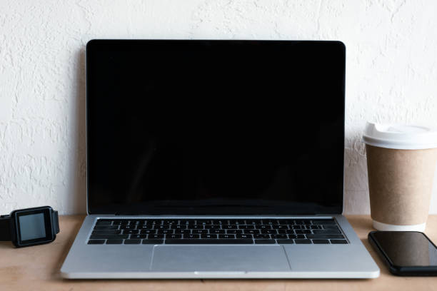istock laptop with blank screen, smartwatch, smartphone and coffee to go on table 1037679958