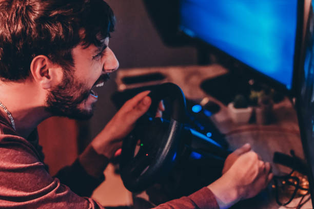 Man playing car racing video game at home