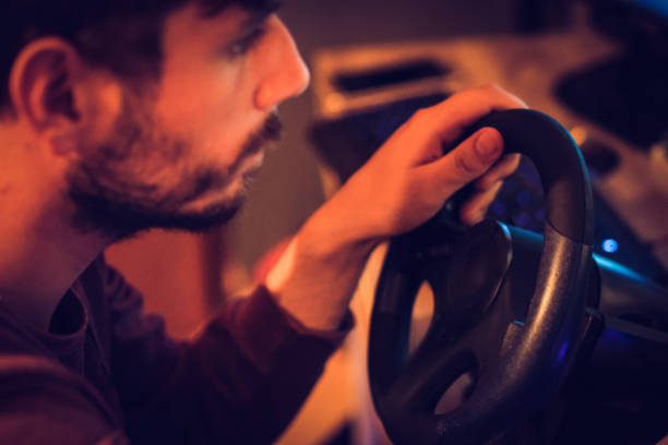istock Man playing car racing video game at home 1037684102