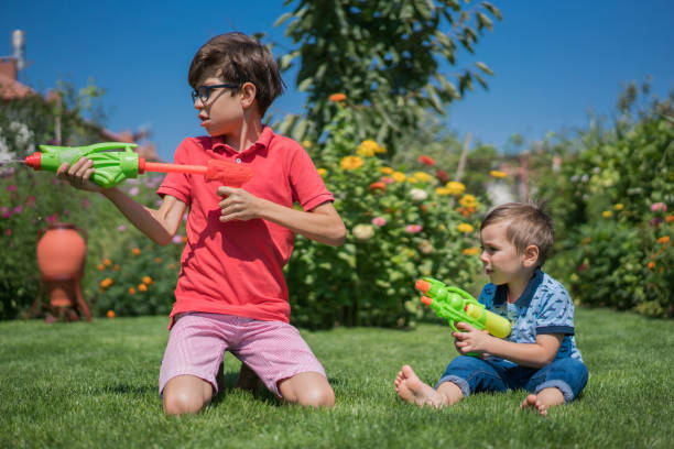Boy in a life jacket with a water gun on the seashore