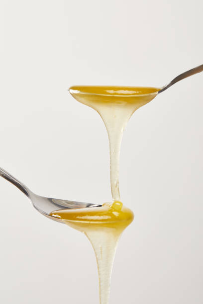 istock close up view of spoons with honey on white background 1037699564