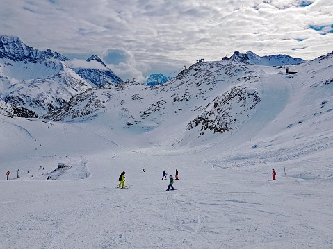 skiers on the ski slope, picturesque alpine landscape