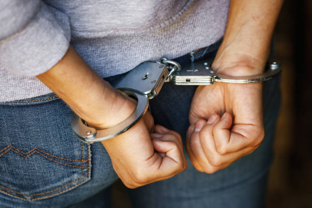 istock Hands behind their backs fastened with handcuffs, close-up 1037742836