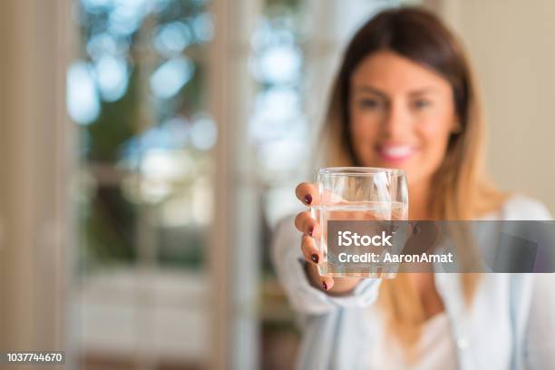 Hermosa Joven Sonriente Sosteniendo Un Vaso De Agua En El Hogar Concepto De Estilo De Vida Foto de stock y más banco de imágenes de Agua