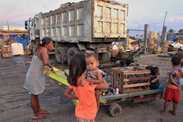 Filipino mother takes her children home. Carbon Market-Cebu City-Philippines-0704 Cebu, Philippines-October 18, 2016: Filipino mother takes her children home in a flatbed trolley through the debris of a business day-Carbon Market-located where coal was unloaded from the railroad. wood and wire fence designs pictures stock pictures, royalty-free photos & images
