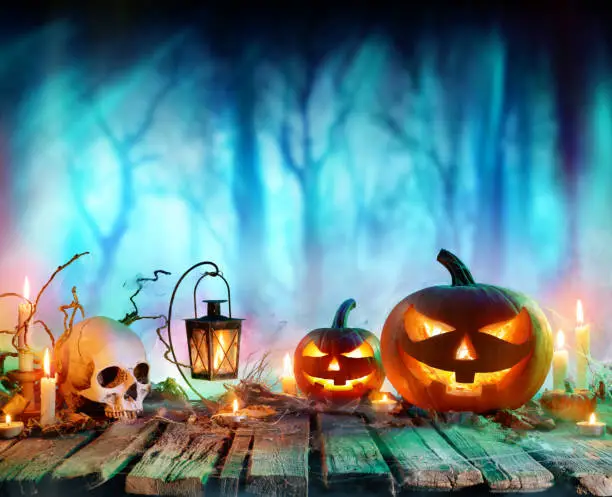 Pumpkins And Candles On Table In Misty Forest - Halloween Background