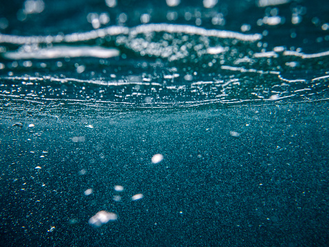 Background of air bubbles underwater, dark sea