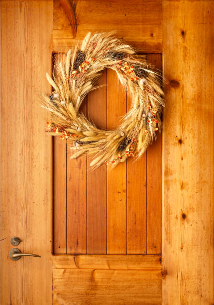 House home front door Fall autumn Thanksgiving decorations country style rustic wreath made of natural botanical materials on wood background
