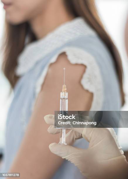 Immunization And Vaccination For Polio Flu Shot Influenza Or Hpv Prevention With Woman Having Vaccine Shot With Syringe By Nurse For World Immunization Week And International Hpv Awareness Day Stock Photo - Download Image Now