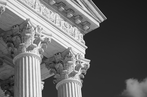 Close-up in black and white of the classically detailed US Supreme Court building in Washington, DC, USA