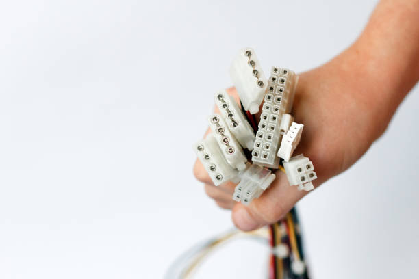 hand holds power cables from power supply unit on white background, PC motherboard power cables and connectors, 4pin peripheral connector, ATX 20+4 pin.