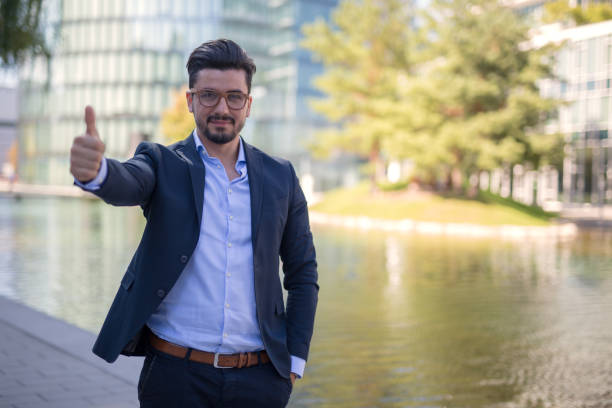 istock Handsome young businessman holding thumbs up into the camera 1037819976