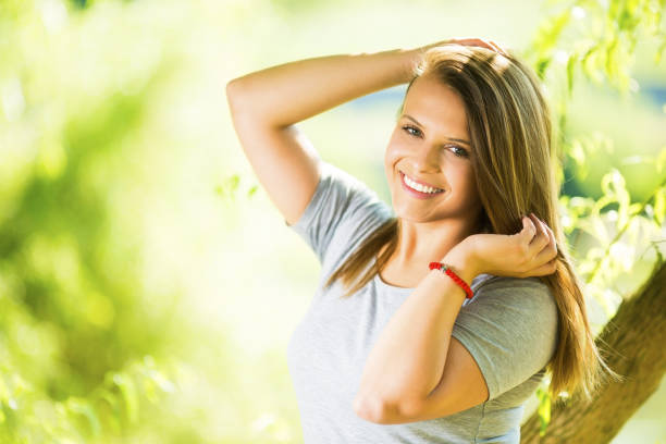 istock Young woman leaning on a tree in park 1037834684