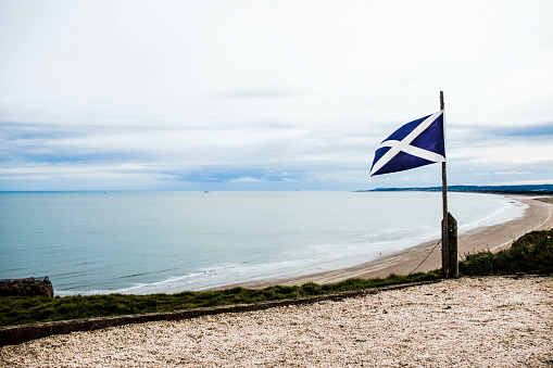 Scottish flag on the sea background. St Cyrus beach, Scotland.
