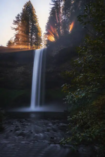 Morning light beams over south falls at Silver Falls State Park, Oregon.