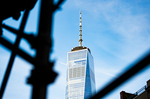 (selective focus) The beautiful One World Trade Center Tower seen through construction scaffolding in Manhattan, New York, USA.