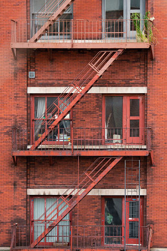 Close-up view of New York City style apartment buildings with emergency stairs along Mott Street in the Chinatown neighborhood of Manhattan NYC.