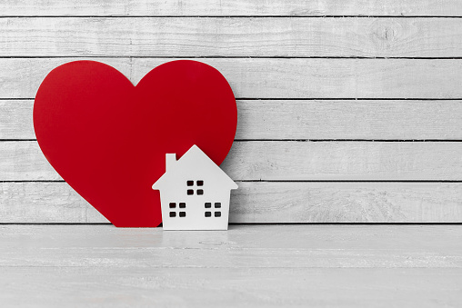 Formó hogar con rojo en forma de corazón en madera blanca sobre fondo blanco de madera photo