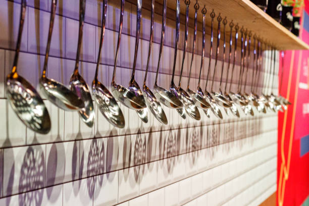 Row of Silver Spoons over a white wall