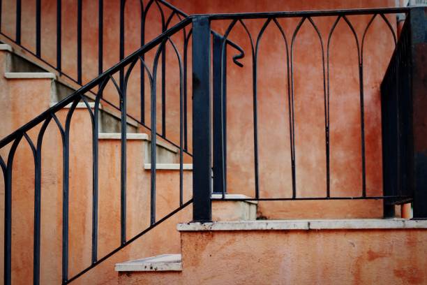 istock Steel cage on stairs, orange wall 1037912500