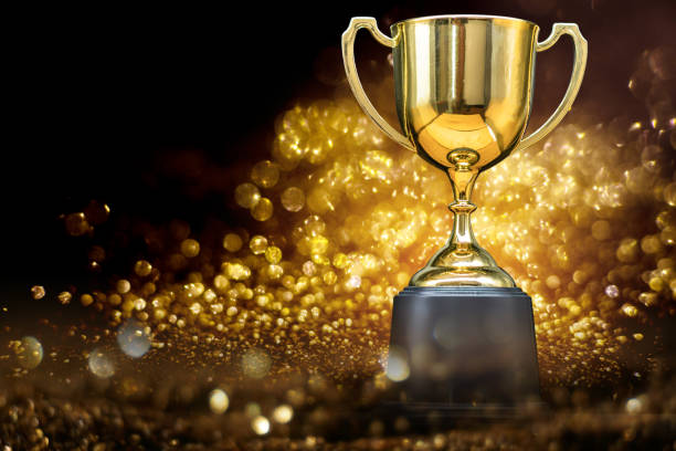 istock trophy over wooden table and dark background 1037936126