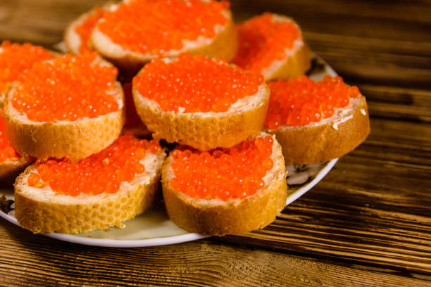 istock Sandwiches with red caviar on wooden table 1037943524