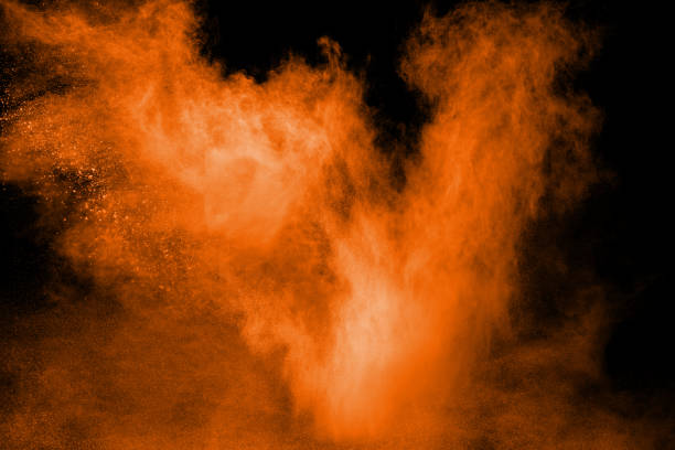 istock orange dust particles explosion on black background. Color powder dust splash. 1037950656