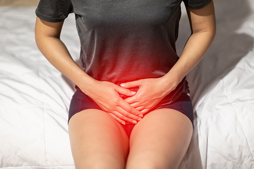 mujer tiene la vejiga o infección urinaria dolor sentado en cama en el dormitorio después de despertar sintiéndose tan enfermedad, concepto salud photo