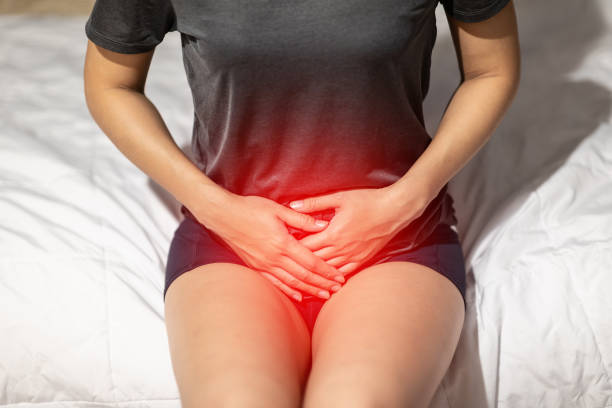 女性、病気、ヘルスケアの概念を感じて目を覚ます後寝室のベッドの上に座って膀胱や尿路感染症の痛みがあります。 - vagina ストックフォトと画像