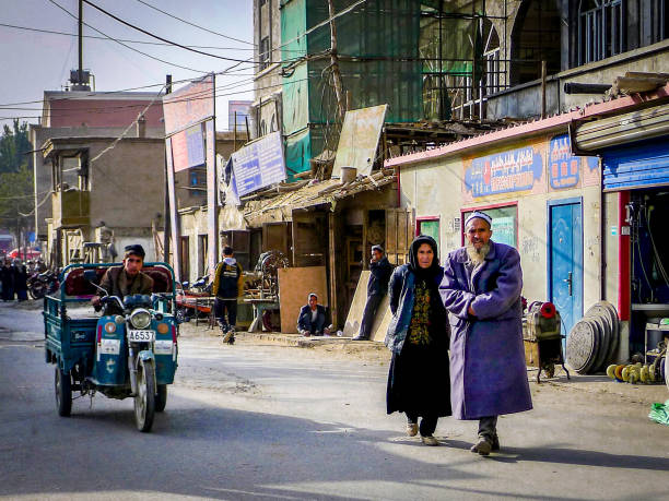 homem velho e mulher caminhando em shache, xinjiang - cultura uigur - fotografias e filmes do acervo