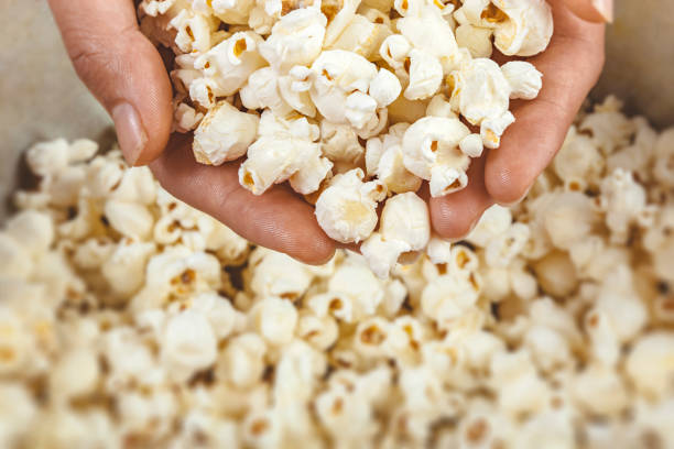 istock Close-up top view of popcorn in hands. 1037970618