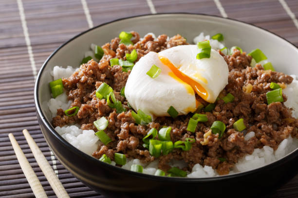 istock Japanese breakfast: stewed beef Soboro with egg benedict, rice and green onion close-up. Horizontal 1037983688