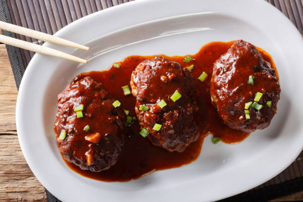 istock Japanese food: hamburg steak or hambagu with a spicy sauce on a plate macro. horizontal top view 1037983728