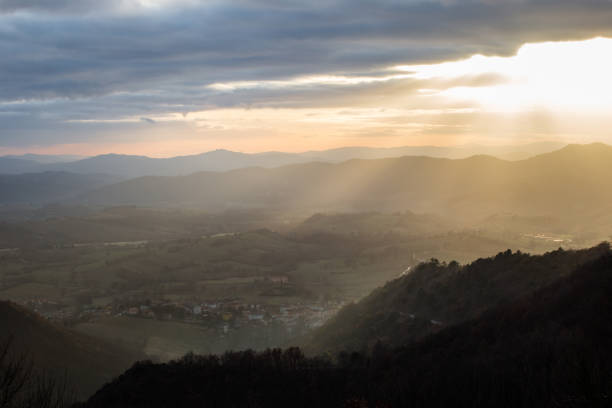 istock Sunrays coming over a valley in Umbria (Italy) with some plants in the foreground 1037984254