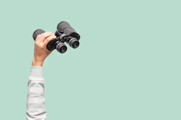 Photo of Woman with binoculars on green background